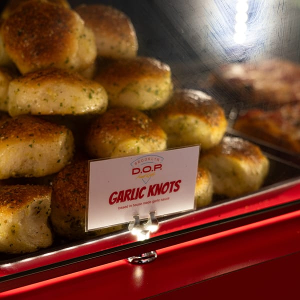 Garlic knots from Brooklyn DOP FastLife displayed in a red-trimmed glass case.